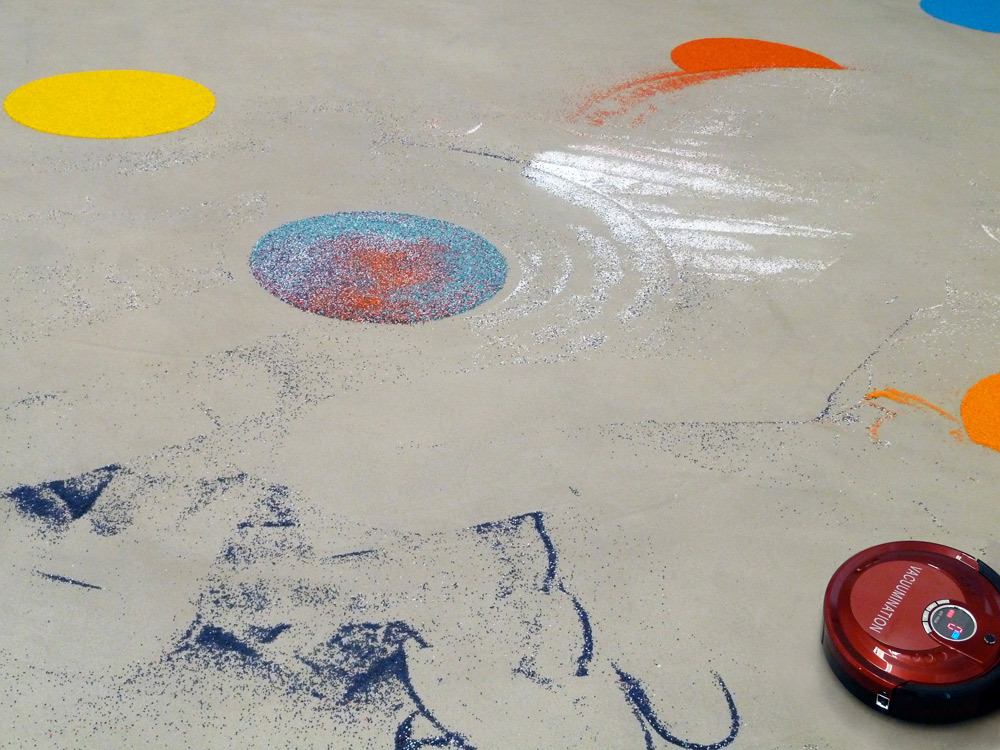 Art, artwork. An installation "Vacuumination" by Nika Span / Nika Špan. Material: A robot vacuum cleaner, coloured gravel. Exhibition: Homeland, MMKK, Klagenfurt, Austria 